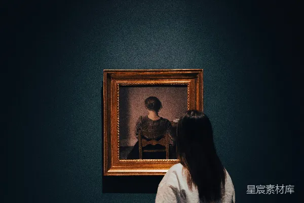 高清摄影 一个女人在一间黑暗的房间中看着一幅画。