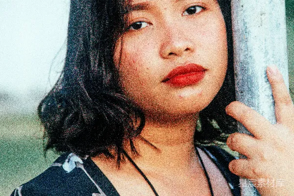 高清摄影 一个女人倚靠在一根柱子上，手搭在柱子上。