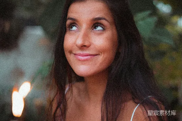 高清摄影 一个穿着白色T恤的女人坐在一盏灯火前面