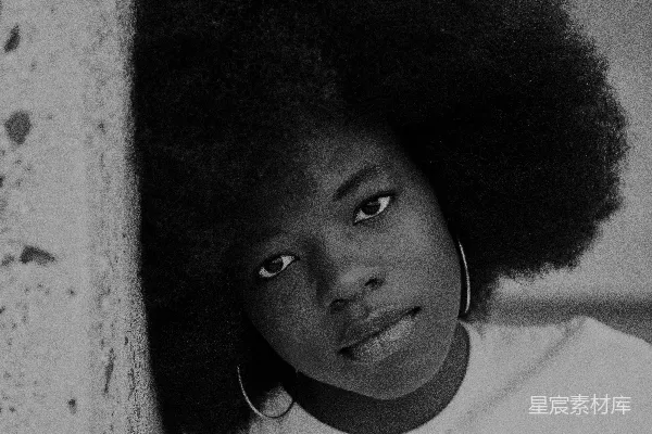 高清摄影 一个留着 Afro 的妇女靠在墙上。