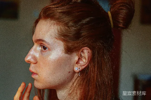 高清摄影 一个有着雀斑头发的女人正在举手遮住她的脸。