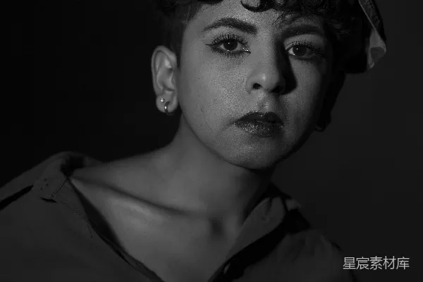 高清摄影 一位身穿黑白照片中一位留着 curly 头发的女性。