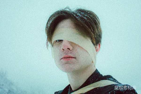高清摄影 脸上绑着绷带的男人站在雪中。