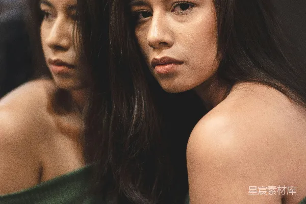 高清摄影 身穿绿色露肩上衣的女子站在房间内的镜子前