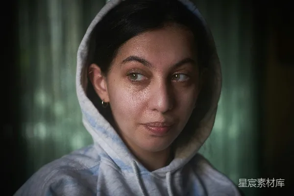 高清摄影 一个穿着连帽卫衣的女人正在看着镜头。