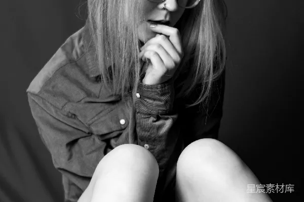 高清摄影 一个戴眼镜、穿着衬衫的女人正严肃地摆姿势。