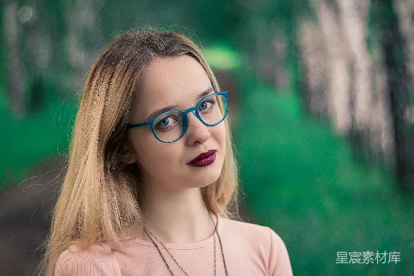 高清摄影 浅焦点照片中的戴着眼镜的女人，眼镜是蓝色的。