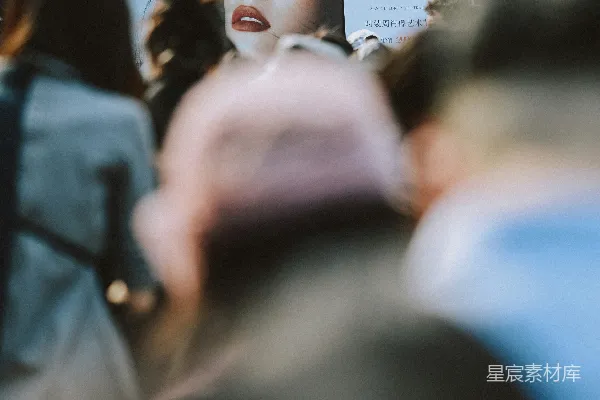 高清摄影 billboard上女人的脸， foreground中有一群人。