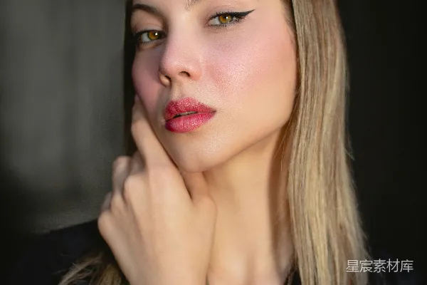 高清摄影 一个女人把手放在下巴上摆姿势拍照。