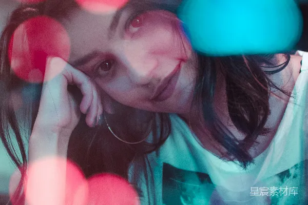 高清摄影 穿着白色上衣的女人照片，背景中有光晕效果的灯光