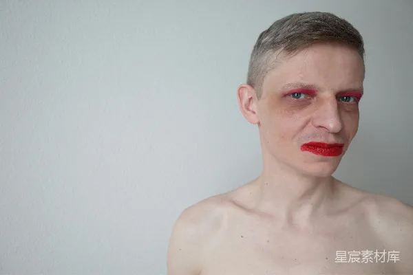 高清摄影 一个涂着红色口红和化妆的男人。