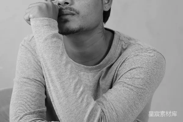 高清摄影 戴眼镜的男人坐在床上。