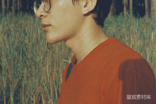 高清摄影 橙色圆领衫的男人戴着黑色框架的眼镜