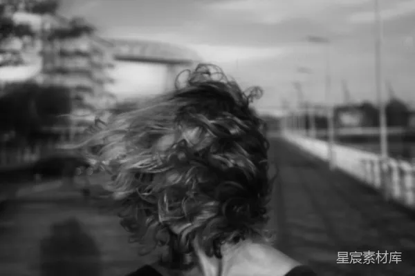高清摄影 一个女人黑白色的照片，她头发在风中飘动。