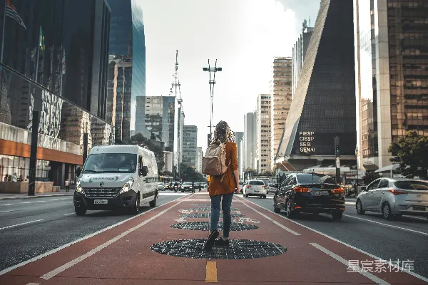 高清摄影 女性在道路上行走，道路两旁有车辆的摄影作品
