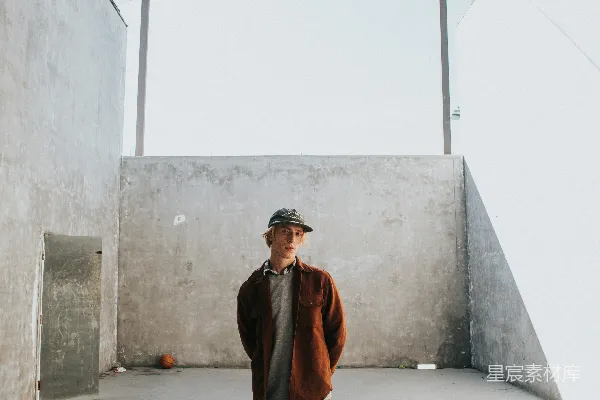高清摄影 穿着棕色夹克的男人靠在墙上