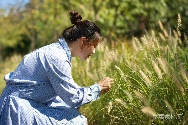 高清摄影 一个穿蓝色连衣裙的女子站在田野里