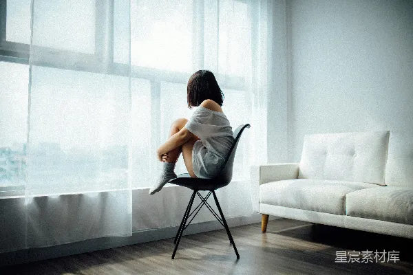 高清摄影 坐在黑色椅子上的女人面前有一扇带白窗帘的玻璃隔断窗。