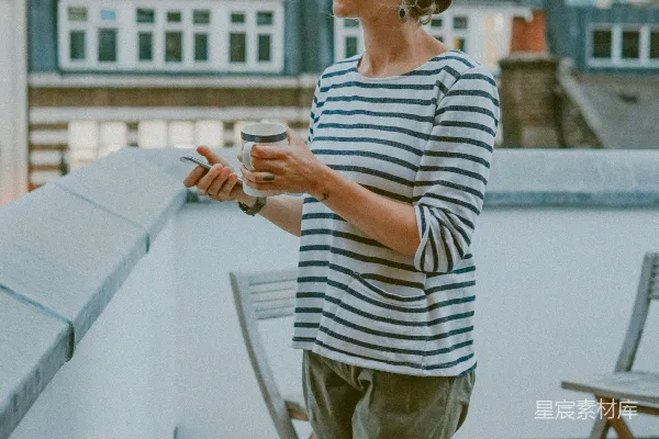 高清摄影 白衬衫黑条纹上衣的女人正在拿着一杯。