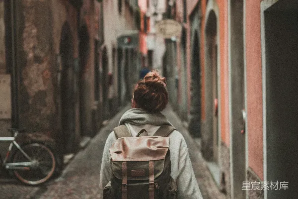 高清摄影 女人在街道上行走，周围是建筑。