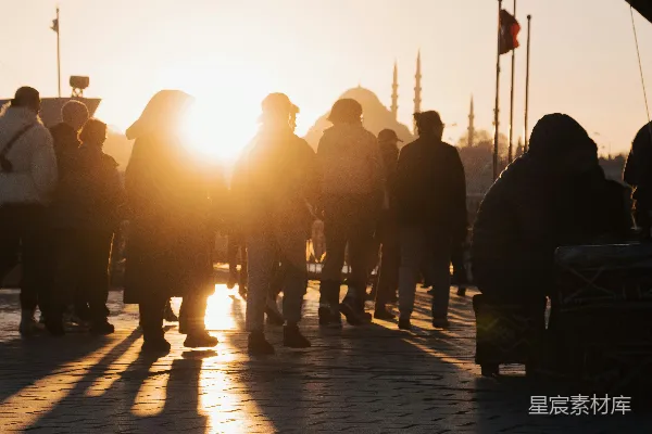 高清摄影 一群人在夕阳下走在人行道上