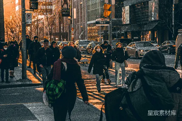 高清摄影 一群人走在旁边有高大建筑物的街道上