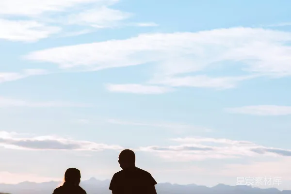 高清摄影 夕阳下两人站在草地上的剪影