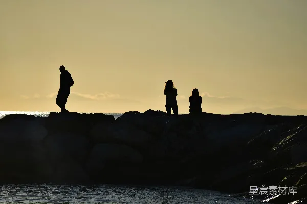 高清摄影 夕阳西下时，海边的轮廓人影