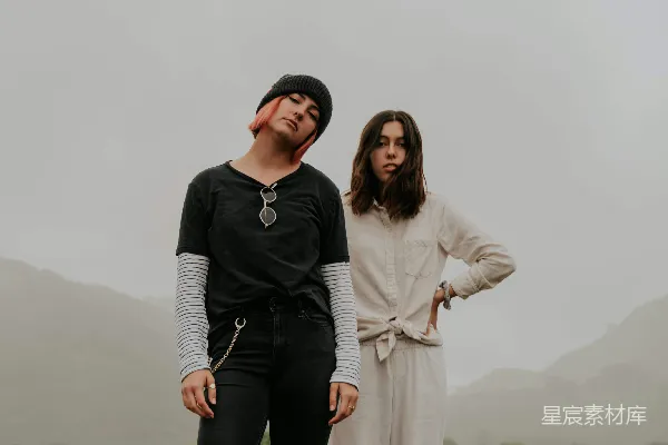 高清摄影 白衬衫女士旁边站着穿着白色长袖连衣裙的女士。