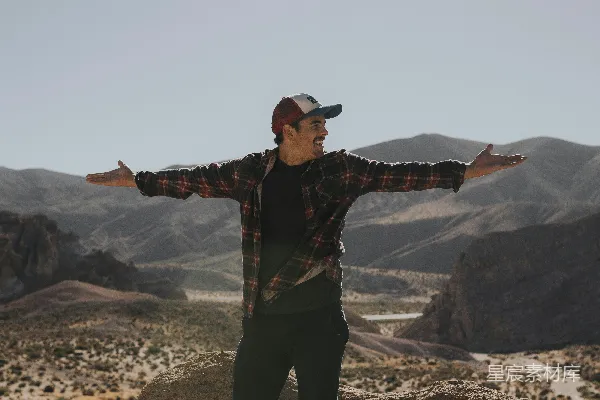 高清摄影 男人张开双臂站在山景背景前