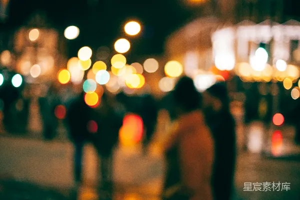 高清摄影 一个模糊的夜景中人们在小镇上行走的画面，周围是散乱的光斑。