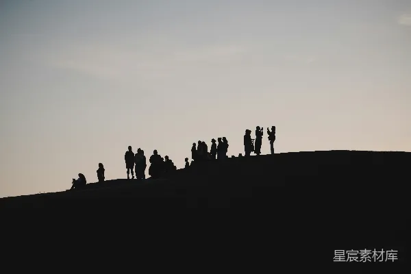 高清摄影 轮廓分明的人群站在山顶，背景是灰蒙蒙的天空。