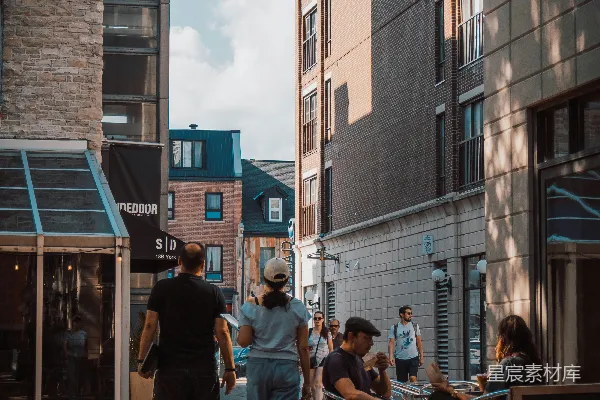 高清摄影 人们在一条阳光明媚的城市街道上散步。