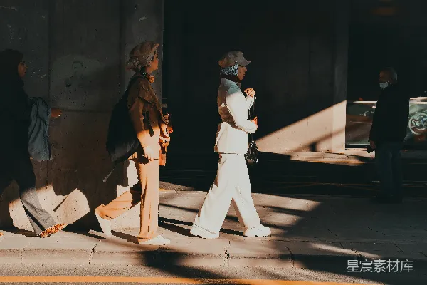 高清摄影 两人走在一条街道旁边的一栋建筑物旁边