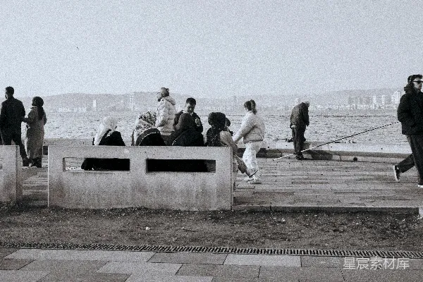 高清摄影 人们聚集在一条 waterfront promenade 上，周围是城市 skyline。