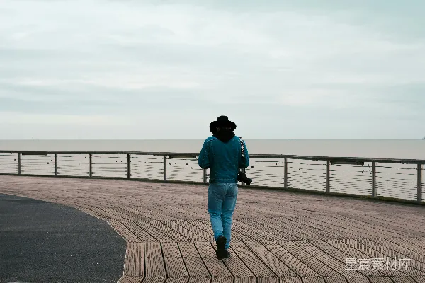 高清摄影 海边一个行人走在木板道上