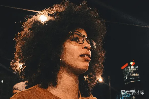 高清摄影 夜间专注于身穿棕色圆领上衣并佩戴黑色框架眼镜的女性的摄影