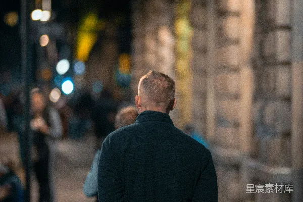 高清摄影 一个男人站在夜间的 sidewalk 上