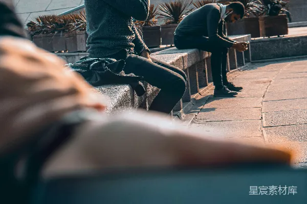 高清摄影 黑色夹克的男人坐在棕色木凳上，白天。