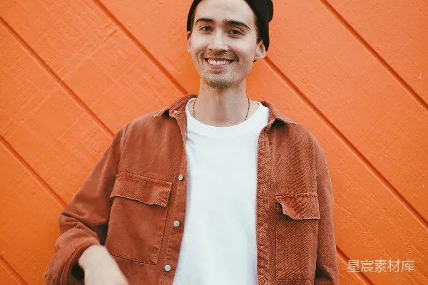高清摄影 穿着棕色夹克的男人站在红色墙旁