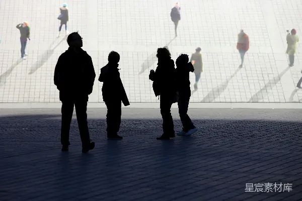 高清摄影 轮廓分明的人们在一条阳光明媚、铺有碎石的小路上行走。