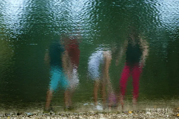 高清摄影 四人站在岸边浅水区。
