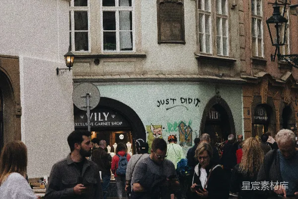 高清摄影 一群人在旁边有高大建筑的街道上行走