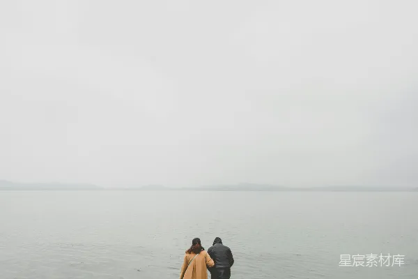高清摄影 两个人在白天站在水边。