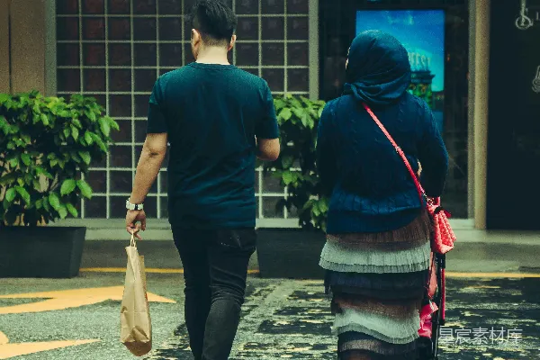 高清摄影 一对夫妇带着《一个安静的地方》走向一家商店。