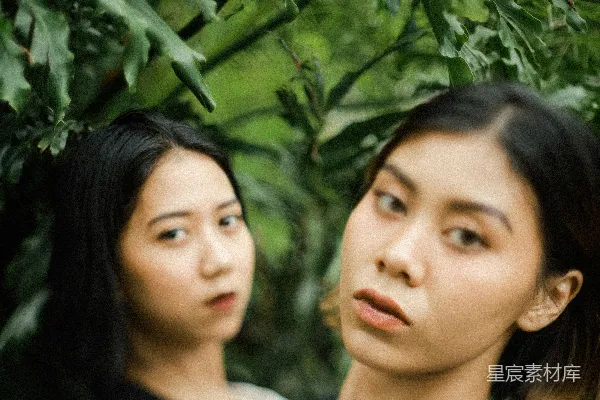 高清摄影 黑色上衣的女人站在绿色植物旁边