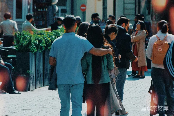 高清摄影 一对人在一条鹅卵石街道上手挽手行走。