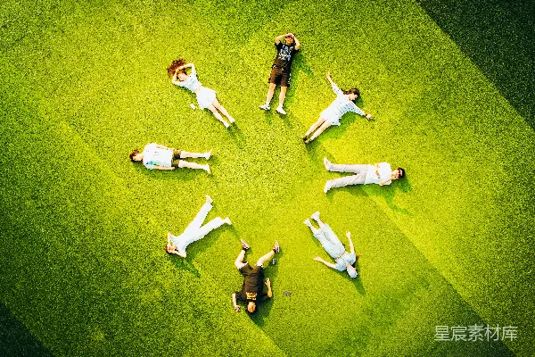高清摄影 人们躺在绿色草地上形成一圈。