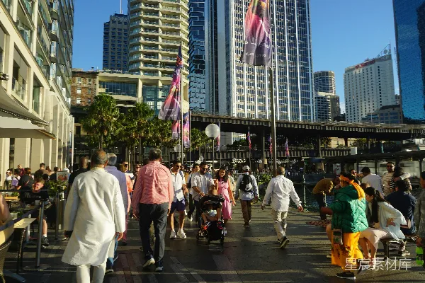 高清摄影 人们走在一条阳光明媚的 waterfront 游散步道上