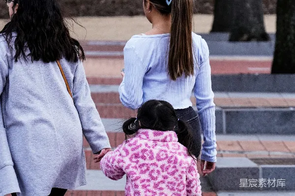 高清摄影 一位妇女和两个孩子在人行道上行走